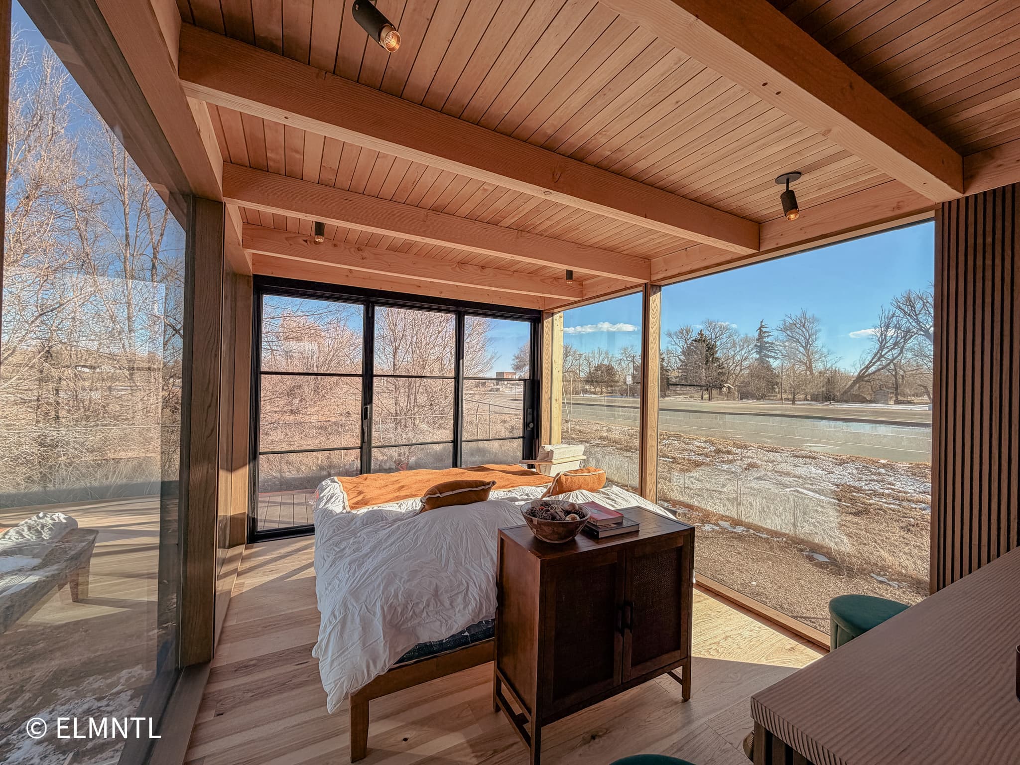 Elmntl Shelter Studio — panoramic bedroom with floor-to-ceiling glass